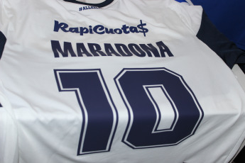 La Plata, Argentina.- En la imágen tomada hoy 6 de septiembre de 2019 en la sede del Club Gimnasia y Esgrima La Plata imágenes de la camiseta del club que comenzará a dirigir Diego Maradona en los próximos días con su nombre, que se vendía en la sede del club, abarrotada de simpatizantes queriendo asociarse al club.  Gimnasia y Esgrima La Plata es un modesto club de la ciudad de La Plata, la capital de la provincia de Buenos Aires, que aunque es uno de los clubes de fútbol más antiguos de la Argentina, nunca ha obtenido un campeonato oficial de primera división y actualmente pelea por no descender a segunda división. La venida de Maradona como Director Técnico es tomada por la institución como una oportunidad para generar más socios y vender su camiseta.