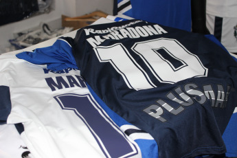 La Plata, Argentina.- En la imágen tomada hoy 6 de septiembre de 2019 en la sede del Club Gimnasia y Esgrima La Plata imágenes de la camiseta del club que comenzará a dirigir Diego Maradona en los próximos días con su nombre, que se vendía en la sede del club, abarrotada de simpatizantes queriendo asociarse al club.  Gimnasia y Esgrima La Plata es un modesto club de la ciudad de La Plata, la capital de la provincia de Buenos Aires, que aunque es uno de los clubes de fútbol más antiguos de la Argentina, nunca ha obtenido un campeonato oficial de primera división y actualmente pelea por no descender a segunda división. La venida de Maradona como Director Técnico es tomada por la institución como una oportunidad para generar más socios y vender su camiseta.